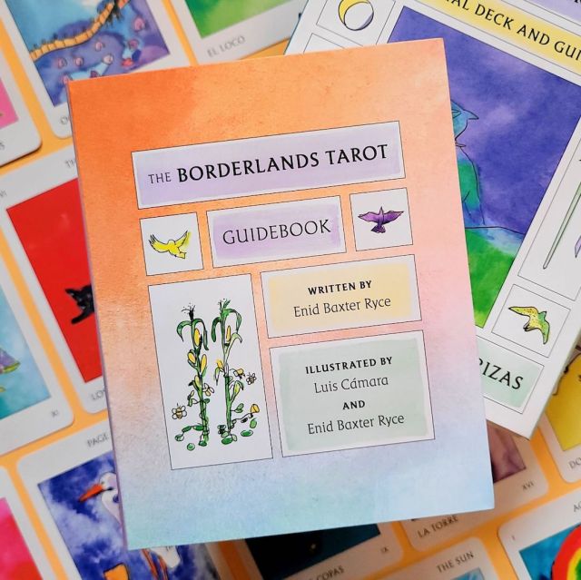 The guidebook of "The Borderlands Tarot / El Tarot de Tierras Fronterizas" laid above face-up cards from the deck, against an orange background